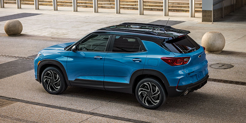 A blue Chevrolet Trailblazer is parked on a paved urban street. The vehicle has a sleek design with black trim and alloy wheels. The scene is calm and modern.